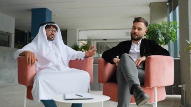 Çağdaş ofis ortamında işbirliği yapan deneyimli Batılı ve Arap işadamları, uluslararası iş sözleşmesi görüşmeleri, belge imzalama ve güvenilir el sıkışma ile ortaklık imzalama