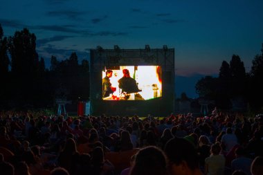 02 Ağustos 2018-Bükreş, Romanya. Halk parkında bekleyenler ve izleyenler açık hava sinemasının projeksiyon ekranında filmin başlamasını bekliyorlar.