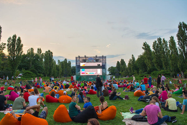 02 August 2018-Bucharest, Romania. People waiting and watching in the public park Herastrau for the movie to start on the projection screen of the open air cinema