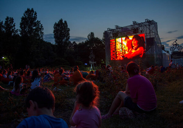 02 August 2018-Bucharest, Romania. People waiting and watching in the public park Herastrau for the movie to start on the projection screen of the open air cinema