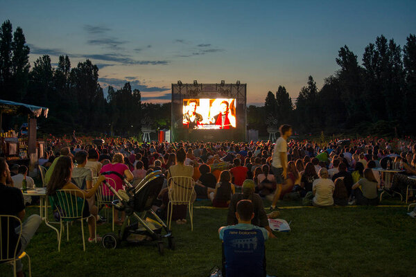 02 August 2018-Bucharest, Romania. People waiting and watching in the public park Herastrau for the movie to start on the projection screen of the open air cinema