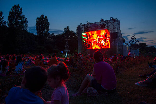 02 August 2018-Bucharest, Romania. People waiting and watching in the public park Herastrau for the movie to start on the projection screen of the open air cinema