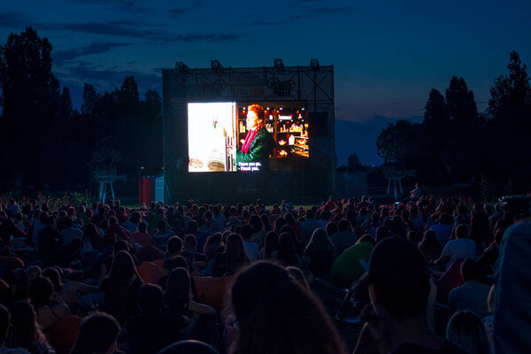 02 August 2018-Bucharest, Romania. People waiting and watching in the public park Herastrau for the movie to start on the projection screen of the open air cinema