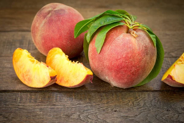 Organic peach and slices of peach on table