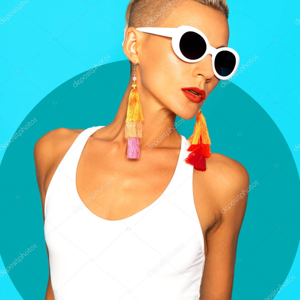 Model in  white swimsuit and stylish beach accessories. Sunglasses and earrings. Beach trend outfit