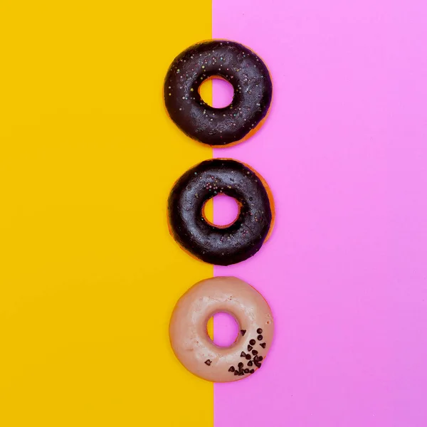 Donuts på en färgad bakgrund. Flat Lay snabbmat konst — Stockfoto