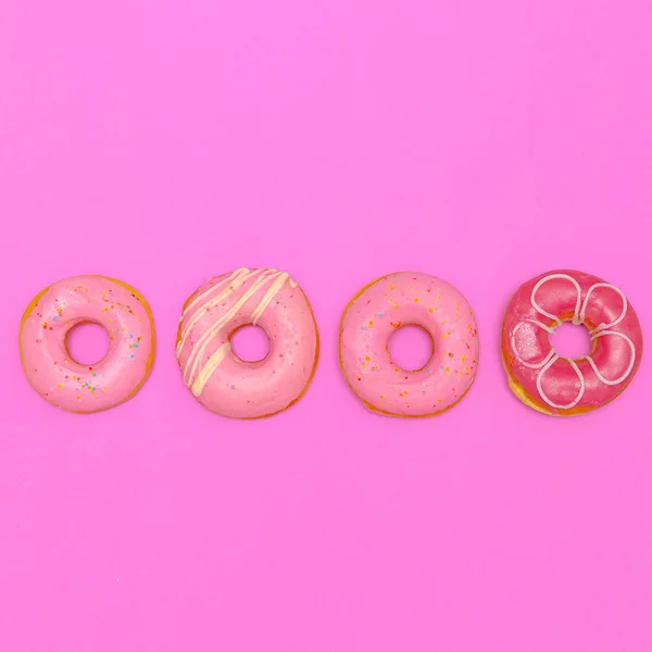 Donuts på en rosa bakgrund. Flat Lay snabbmat konst — Stockfoto