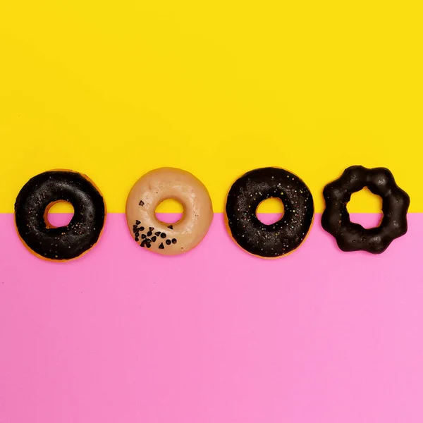 Donuts mis sur un fond coloré. Flat lay restauration rapide minimale — Photo