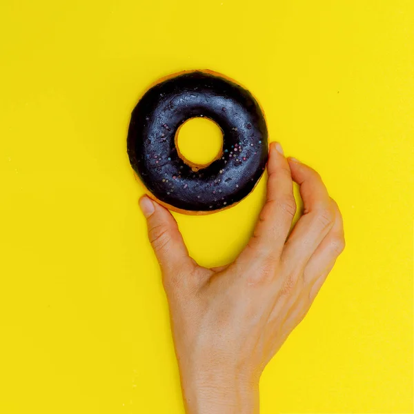 Choklad donut på en gul bakgrund. Flat Lay snabbmat konst. — Stockfoto