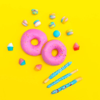 Sarı arka plan üzerinde mix tatlı şeker. Düz lay gıda sanatı