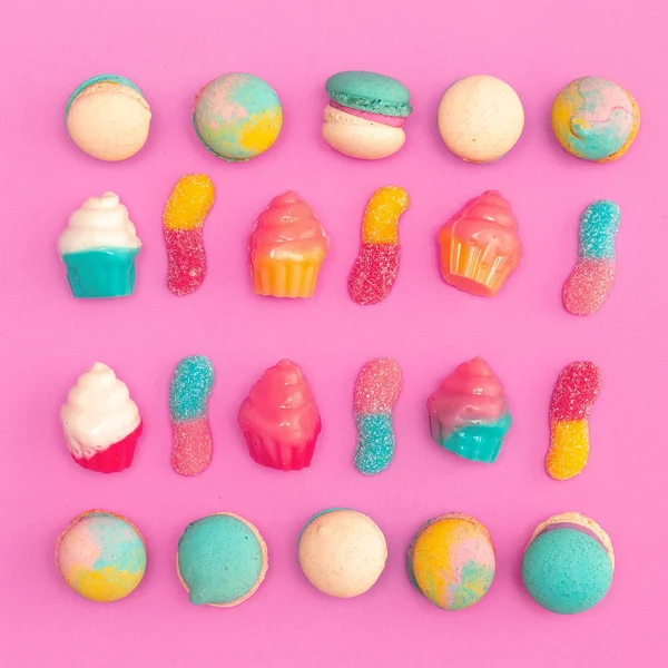 Mezcla de pasteles y dulces sobre fondo rosa. Plano laico comida arte — Foto de Stock