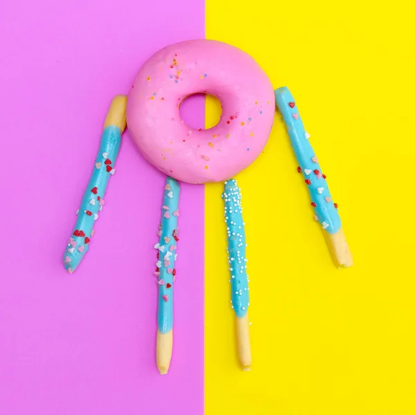 Donut personaggio divertente su sfondo colorato. piatto laico cibo arte — Foto Stock