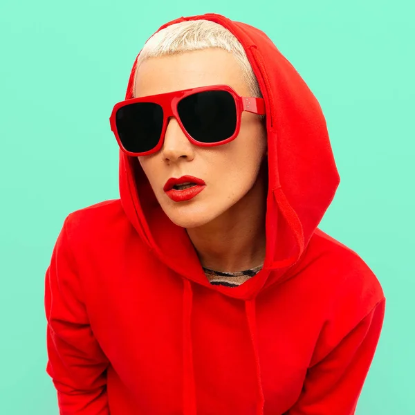 Fashion hipster model in rode Sweatshirt hoodie en zonnebril St — Stockfoto