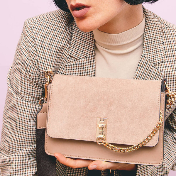 Девушка в клетчатом винтажном костюме и стильном сцеплении
