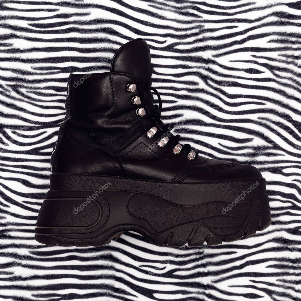 Stylish platform boots on animal print. Fashion minimal flat lay