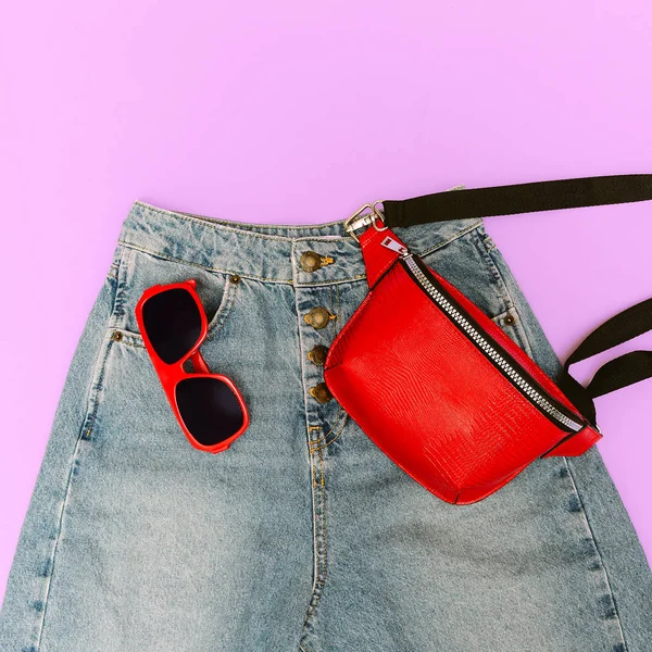 Blue jeans and fashion red accessories. Clutch bag and sunglasse — Stock Photo, Image