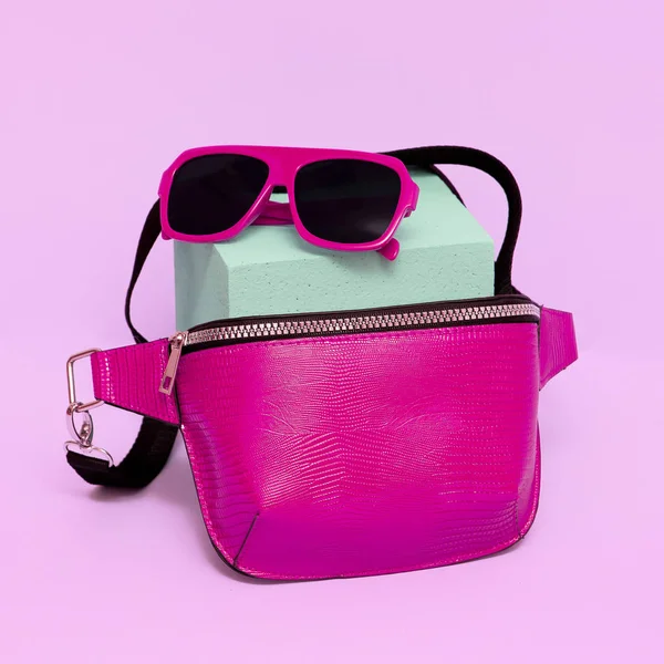 Fashionable pink sunglasses and clutch bag. Glamor concept