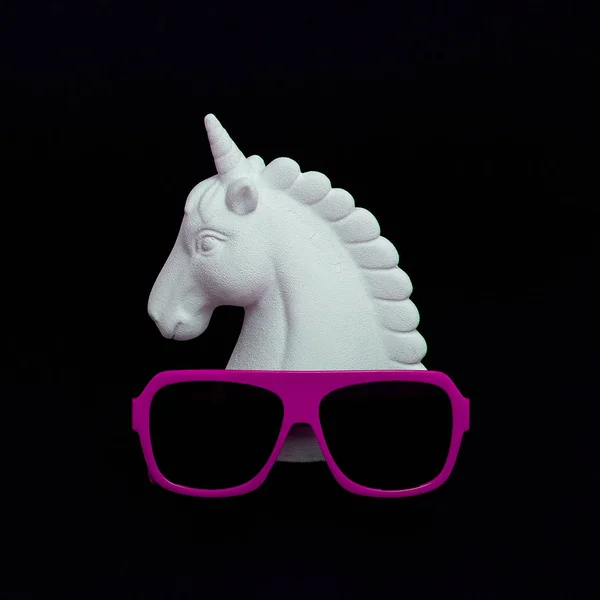 Licorne peinte en blanc et lunettes de soleil élégantes dans l'espace noir. Min ! — Photo