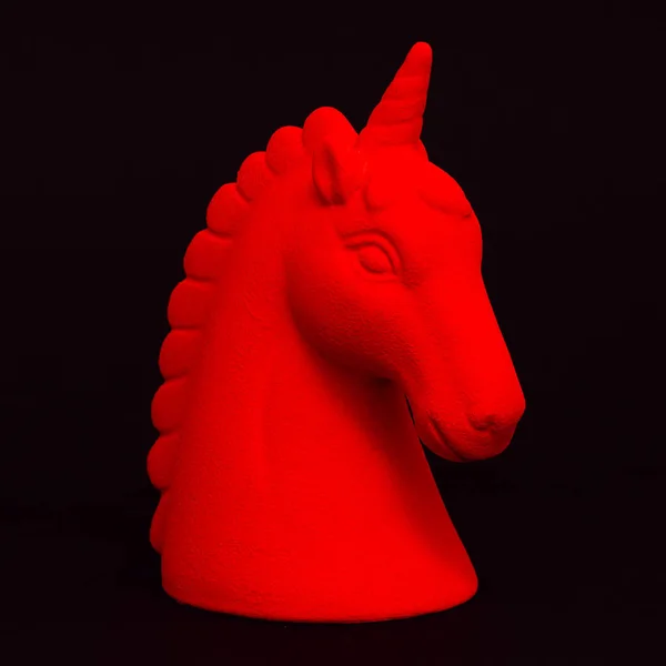 Un recuerdo de unicornio rojo sobre un fondo negro. Mínimo — Foto de Stock