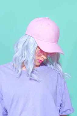 Modaya uygun yaz aksesuarları giyen estetik sarışın kız. Pembe başlıklı Vanilla Pastel renkleri sokak tarzı kıyafet.