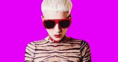 Animasyon gif tasarımı. Pembe arka planda kolyesi ve güneş gözlüklü tuhaf kız portresi.