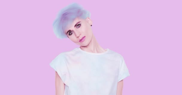 Естетична альтернатива Дівчина з блакитним коротким волоссям, стильна курка позує в студії на синьому фоні. Мода грайливі емоції, стиль і концепція аксесуарів — стокове відео