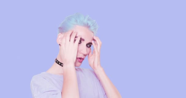 Sexy alternative verspielte Dame mit blauen Haaren und stylischem Casual-Look posiert im Studio vor blauem Hintergrund. Mode-Emotionen, Frisur und Accessoires-Konzept — Stockvideo