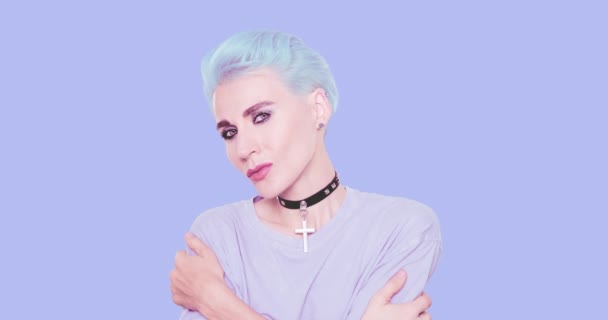 Modelo lúdico alternativo sexy com cabelo azul e aparência casual elegante posando em estúdio contra fundo azul. Penteado de moda e conceito de acessórios — Vídeo de Stock