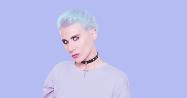 Μόδα Σέξι παιχνιδιάρικο κορίτσι με μπλε μαλλιά και κομψή casual εμφάνιση ποζάροντας στο στούντιο με φόντο το μπλε. Μόδα χτένισμα και αξεσουάρ έννοια — Αρχείο Βίντεο