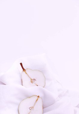 Moda, beyaz tekstil arka planında taze armut olan natürmort hayat sahnesi. Minimalist detaylar estetik.