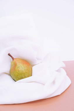 Moda, beyaz tekstil arka planında taze armut olan natürmort yaşam kompozisyonu. Minimalist detaylar estetik.