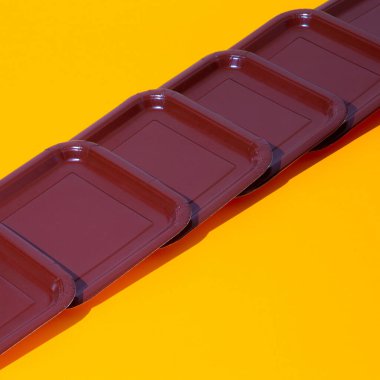 Sarı arka planda izometrik plastik plaka. Çok az. Yine de hayat sanatı. Plastiksiz konsept