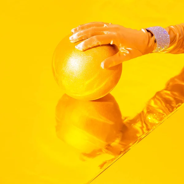 穿着老式手套和手镯的时尚手握着闪闪发光的金球 最小的静物艺术 新年概念 — 图库照片