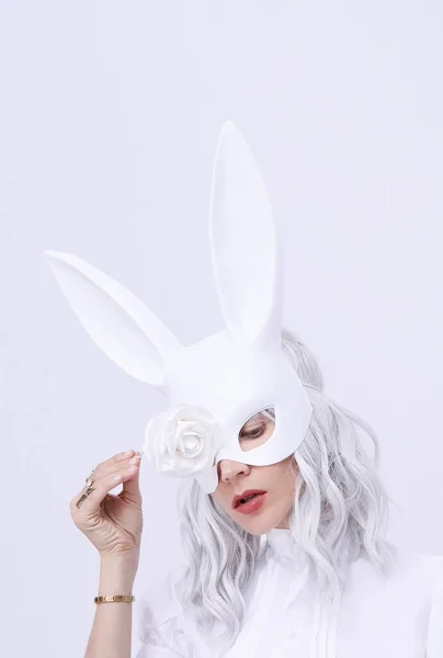 スタイリッシュな白のミニマルな空間でウサギのマスクの若いブロンドの女の子 ファッションお祝いクリスマス お正月パーティーのお祝いのコンセプト — ストック写真