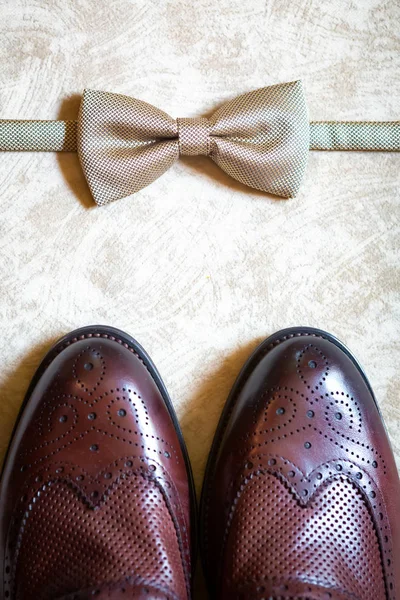 A set of clothes for the groom. Wedding shoes, belt, tie, perfume, cufflinks. The whole set of men is made in brown color. Luxury suite for real men