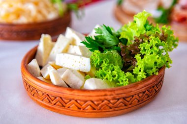 Ziyafet masasına servis edilmiş. Peçeteli, bardaklı ve salatalı şarap bardakları.