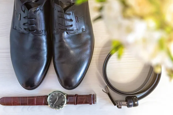 A set of clothes for the groom. Wedding shoes, belt, tie, perfume, cufflinks. The whole set of men is made in brown color. Luxury suite for real men