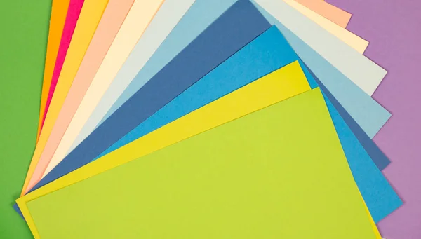 sheets of colored paper. Many colored sheets of paper are laid out in the harsh composition. background of colored paper.