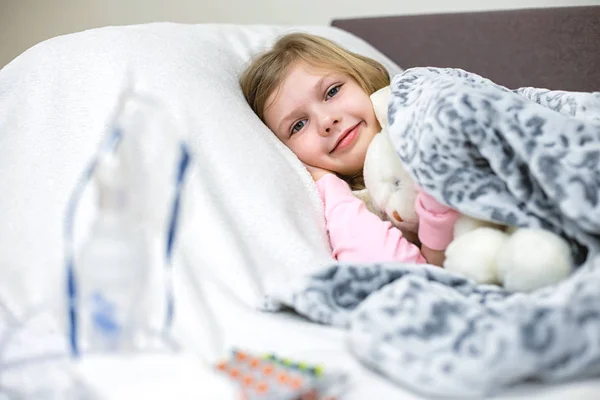 Una niña enferma toma medicamentos y come fruta. . — Foto de Stock