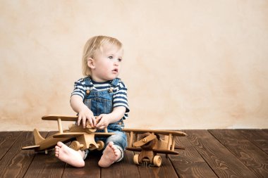 Mutlu bir çocuk evde oynamak. Bebek Çocuk oyuncak uçak. Yaz tatil ve seyahat, rüya ve hayal gücü kavramı