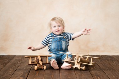 Mutlu bir çocuk evde oynamak. Bebek Çocuk oyuncak uçak. Yaz tatil ve seyahat, rüya ve hayal gücü kavramı