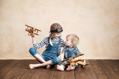 Mutlu çocuklar evde oynamak. Erkek bebek ve oyuncak uçaklarınla kızla. Yaz tatil ve seyahat, rüya ve hayal gücü kavramı