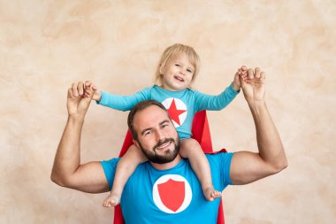 Adam ve çocuk süper kahraman evde. Süper kahraman baba ve oğul birlikte eğleniyor. Aile tatil kavramı. Mutlu babalar günü