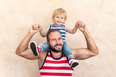 Adam ve çocuk evde. Baba ve oğul birlikte eğleniyor. Aile tatil kavramı. Mutlu babalar günü