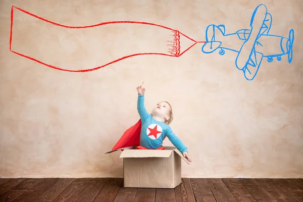 スーパー ヒーローの子 スーパー ヒーローの子供が自宅で再生します ボックスの概念の外で考える — ストック写真
