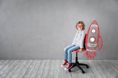 Roket, atış studio ile sandalye üzerinde oturan mutlu çocuk