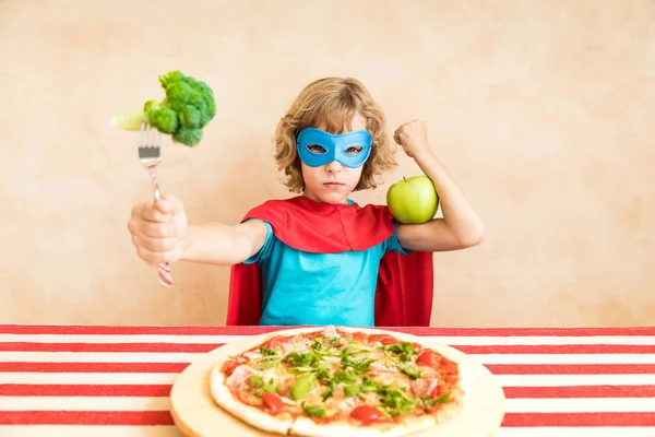 Criança Super Herói Comendo Vegetais Superalimentares Com Pizza Mesa — Fotografia de Stock