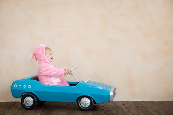 Funny Kid Wearing Easter Bunny Costume Riding Toy Car Home — Stock Photo, Image