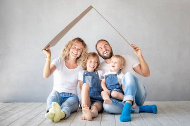 Yeni evinde oynayan iki çocukları ile mutlu bir aile. Baba, anne ve çocuk birlikte eğleniyor. Hareketli ev gün ve gayrimenkul konsept