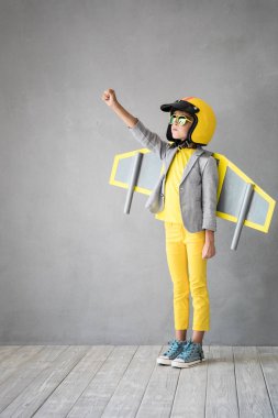 Oyuncak jetpack ile mutlu bir çocuk. Çocuk pilot evde eğleniyor. Başarı, yenilik ve lider kavramı